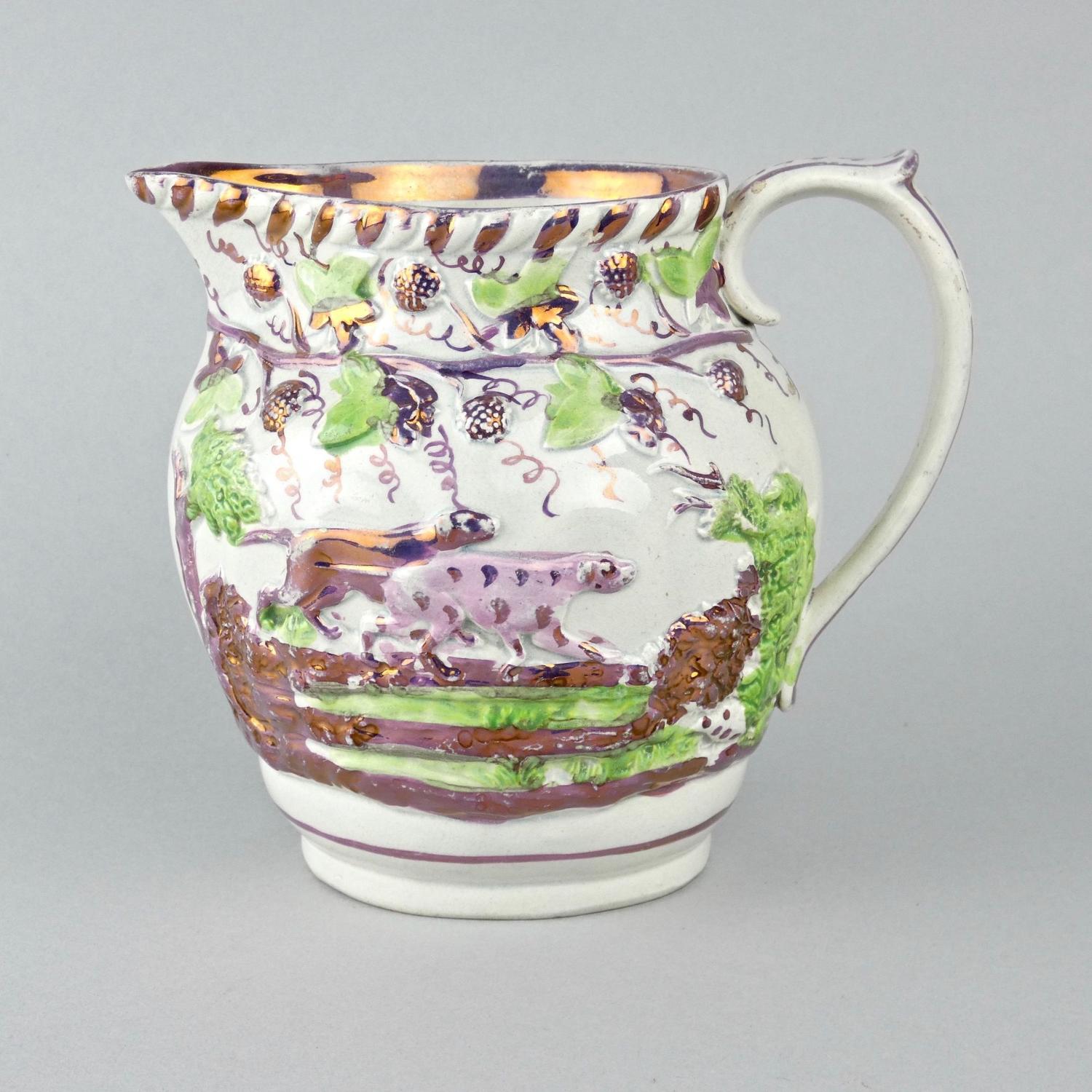 Pink lustre jug moulded with dogs.