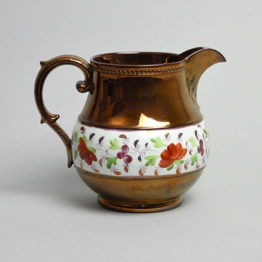 Copper lustre jug with enamelled flowers